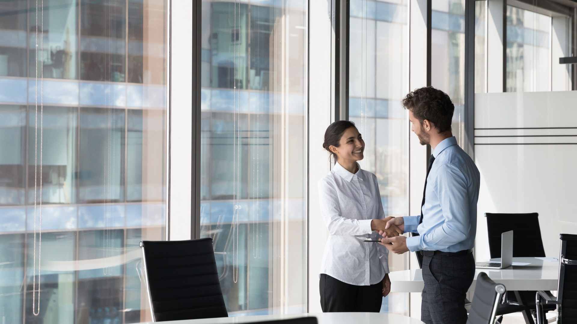 Multi ethnic client and manager make deal, handshaking, express respect